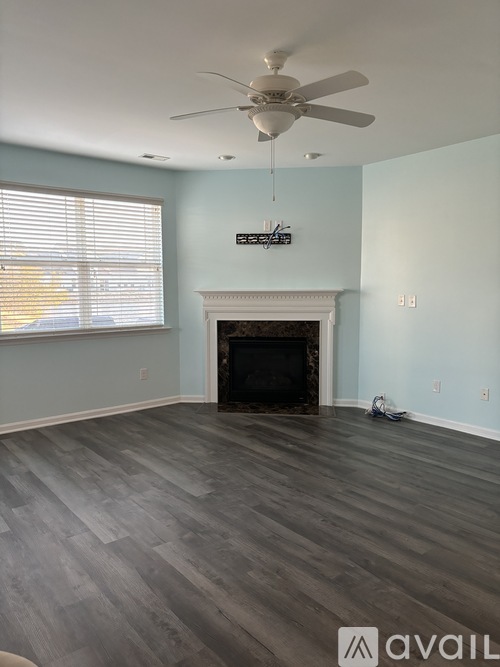 A room with a fireplace and a fan.