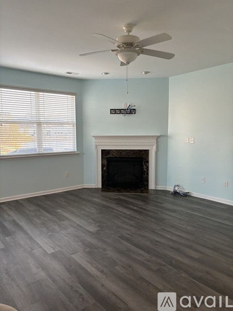 A room with a fireplace and a fan.