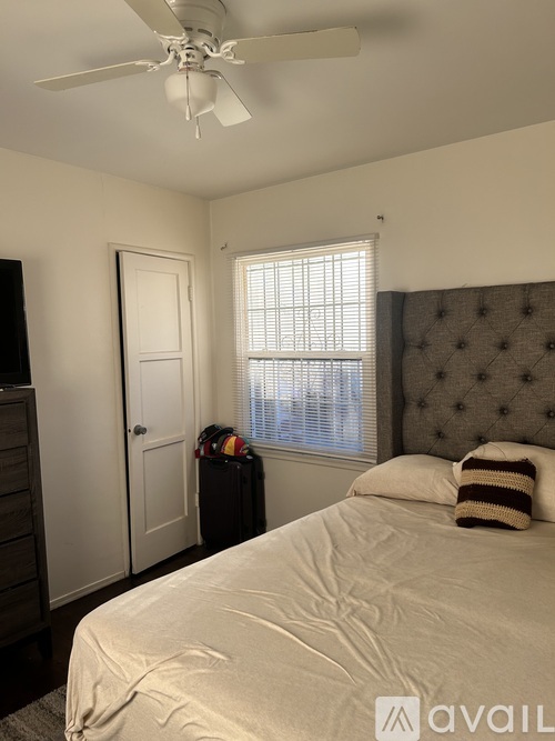 A bedroom with a bed, dresser, and window.