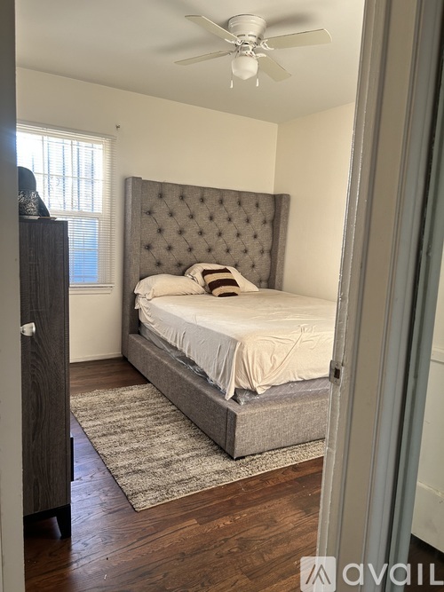 A bedroom with a large bed and a ceiling fan.
