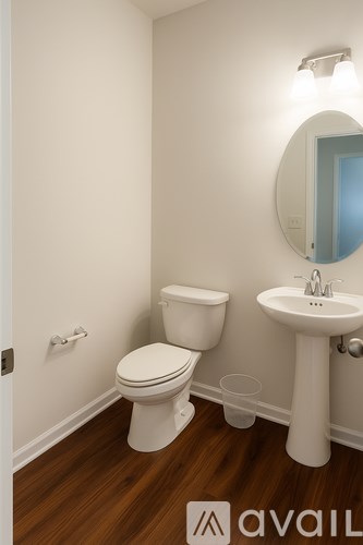 A room with three white doors and wooden floors.