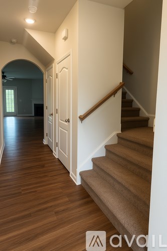 A bathroom with a toilet, a towel bar, and a bathtub.