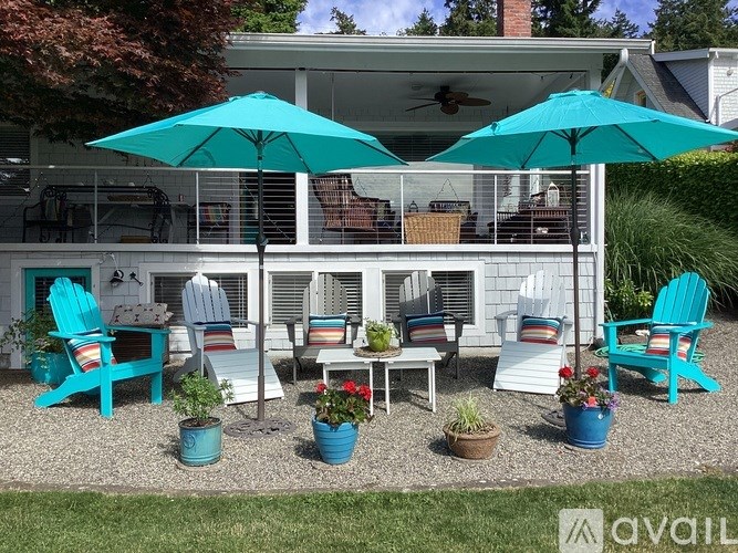 A patio with blue chairs and umbrellas.