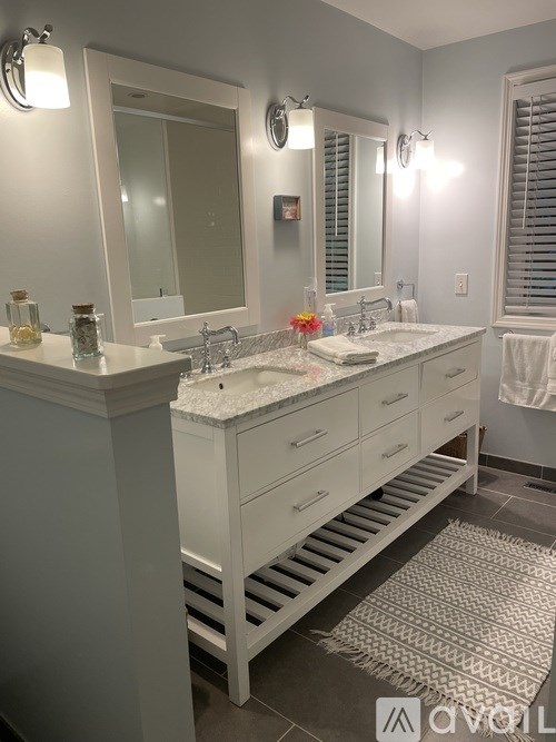 A bathroom with a white vanity and a large mirror.