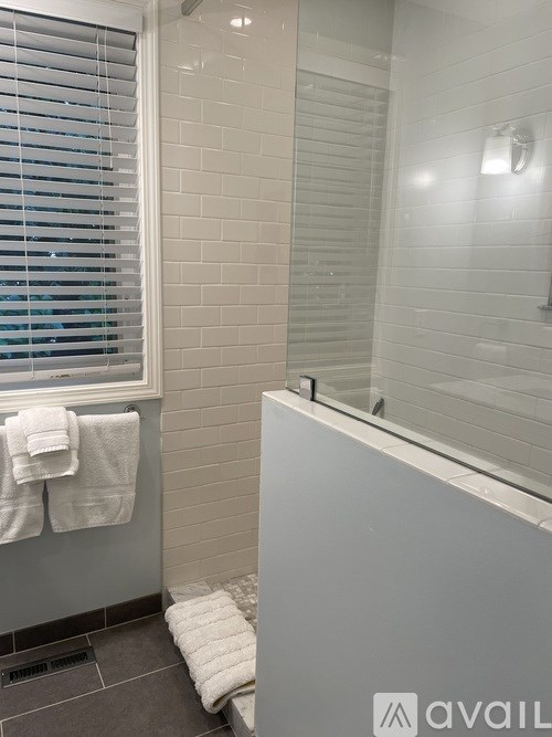 A bathroom with a white towel hanging on the window.