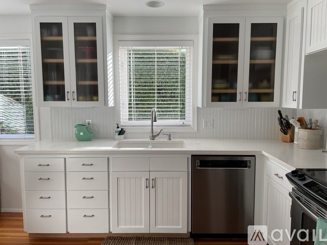 A kitchen with white cabinets and a stainless steel dishwasher.