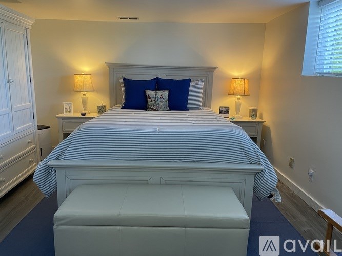 A bedroom with a large bed and two lamps on either side of the bed.