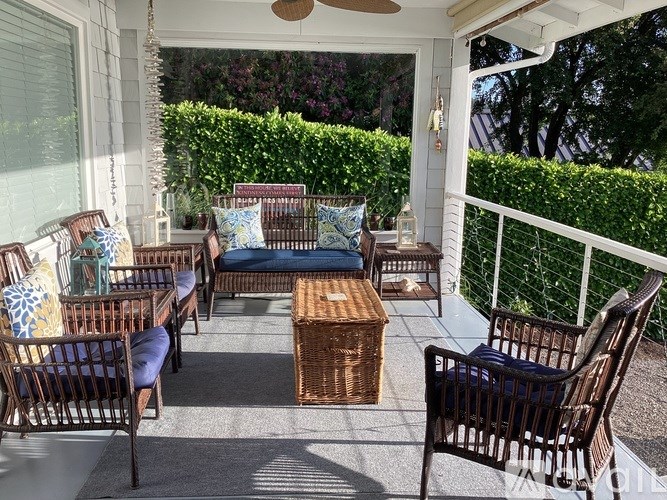 A patio with a white railing and a white ceiling fan.