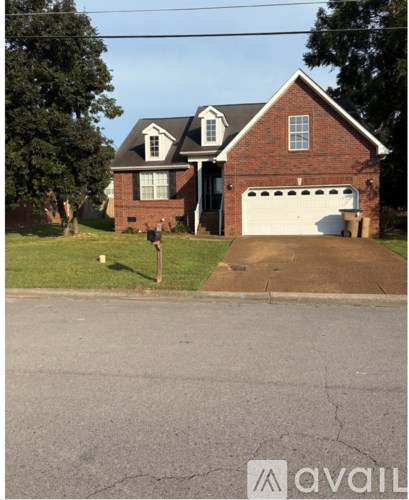 A house with a garage and a driveway in front.