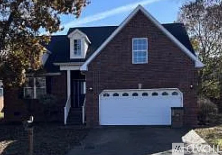 A two-car garage is attached to a brick house.