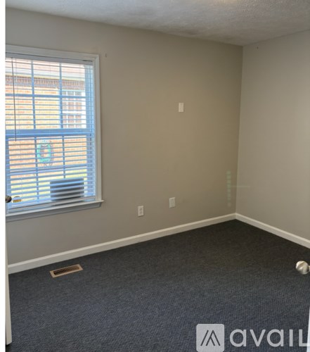 A room with a ceiling fan and a window with blinds.