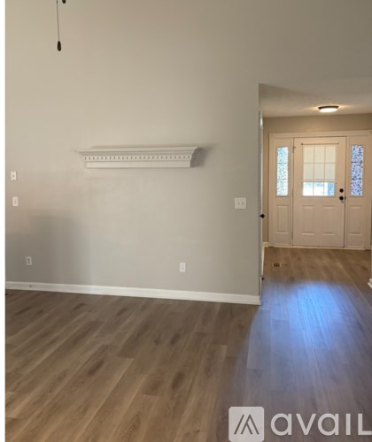 A room with wooden flooring and a white door.