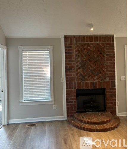 A brick fireplace with a wood burning fire inside.
