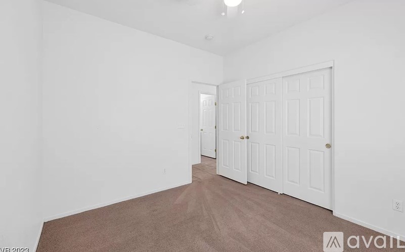 A room with white walls and a brown carpet.