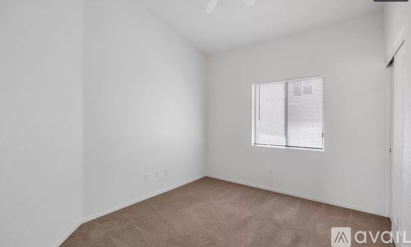 A room with a window and carpeted floor.
