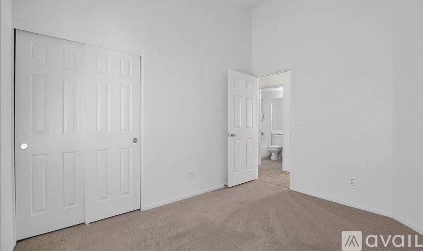 A room with a white door and carpeted floor.
