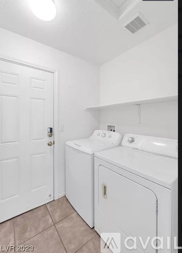 A white bathroom with a washer and dryer.