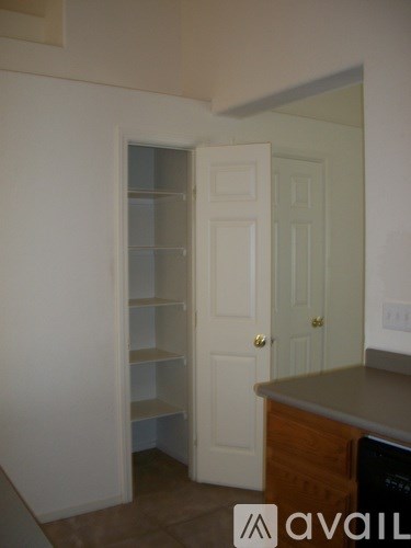A kitchen with a white door and a brown counter.