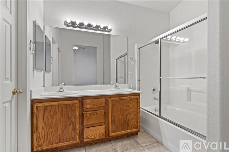 A bathroom with a wooden vanity and a walk-in shower.