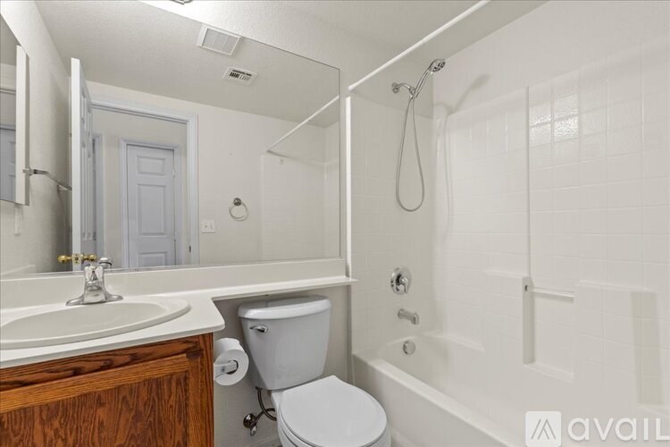 A white bathroom with a toilet, sink, and bathtub.