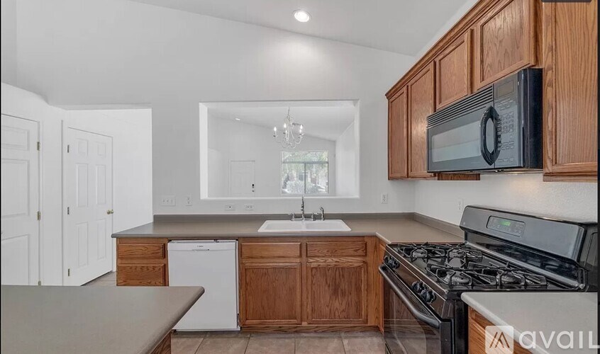 A kitchen with wooden cabinets and a white dishwasher.