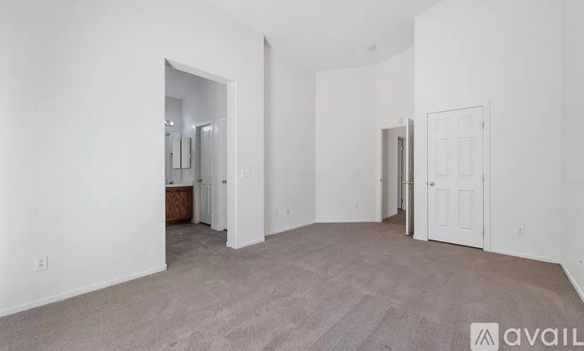 A spacious room with carpeted floor and white walls.