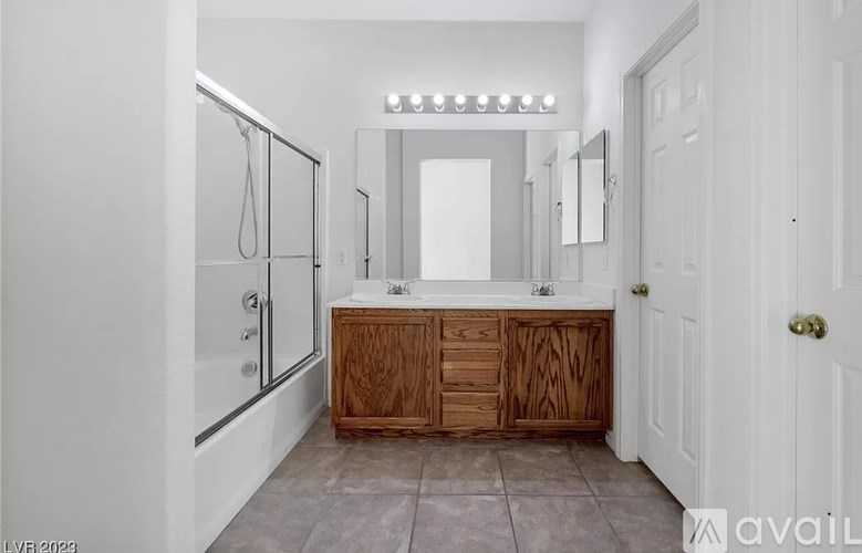 A bathroom with a wooden vanity and a walk-in shower.