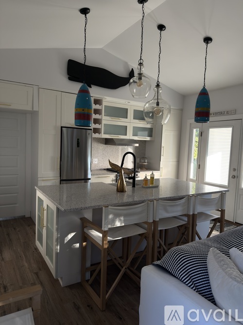 A kitchen with a white island and a refrigerator with a surfboard design on it.