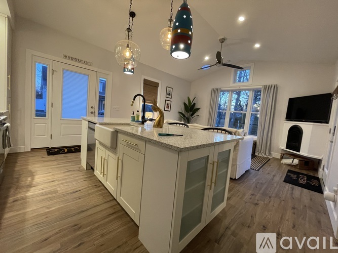 A kitchen with a center island and a television on the wall.
