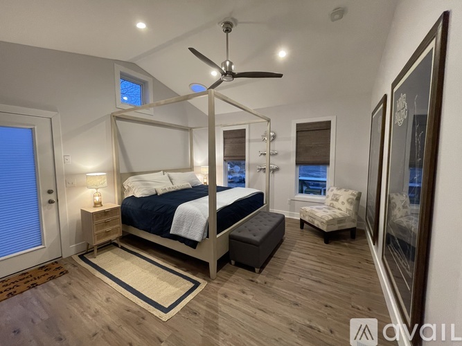 A bedroom with a large bed and a ceiling fan.