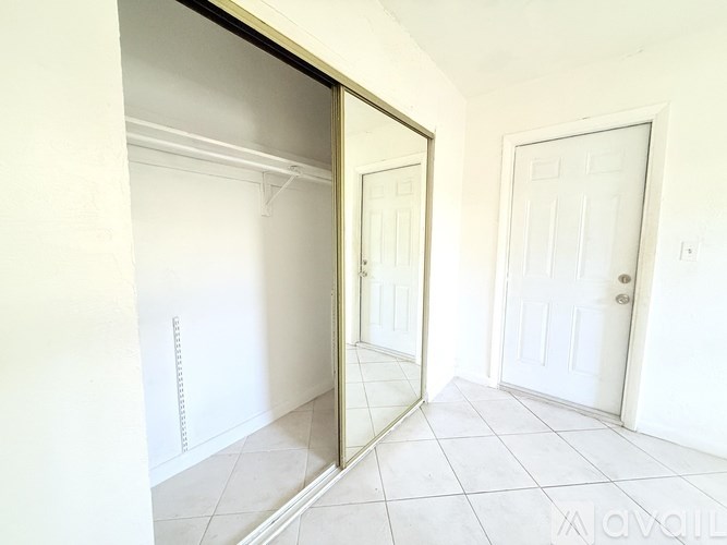 A white room with a sliding door and a white door.