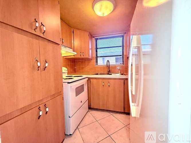 A kitchen with wooden cabinets and a white fridge.