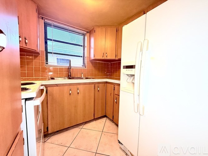 A kitchen with wooden cabinets and a white refrigerator.