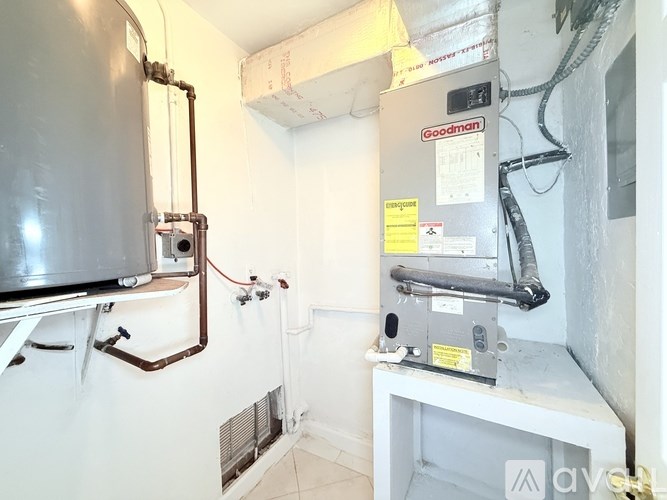 A Goodman furnace and air conditioner unit in a small room.