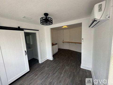 A room with a ceiling fan and a window with blinds.