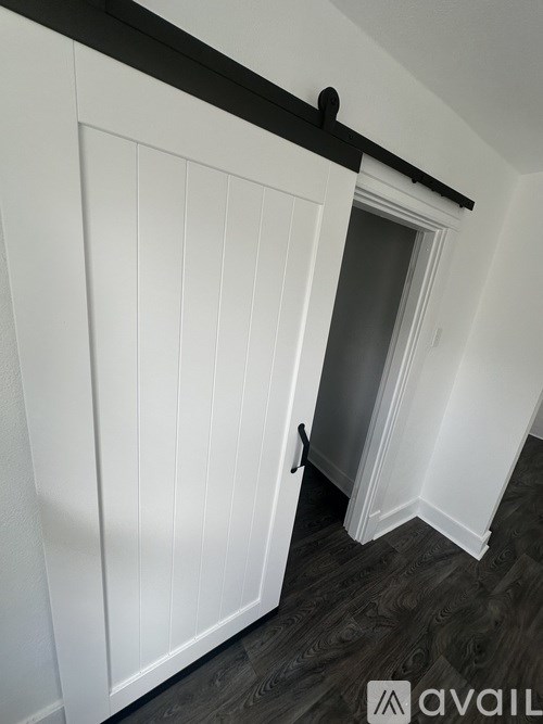 A white door with a black handle is open.