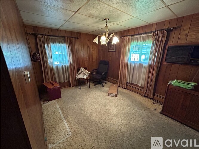 A living room with a chair, a table, and a television.