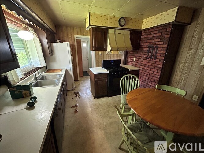 A kitchen with a table and chairs in front of a brick wall.