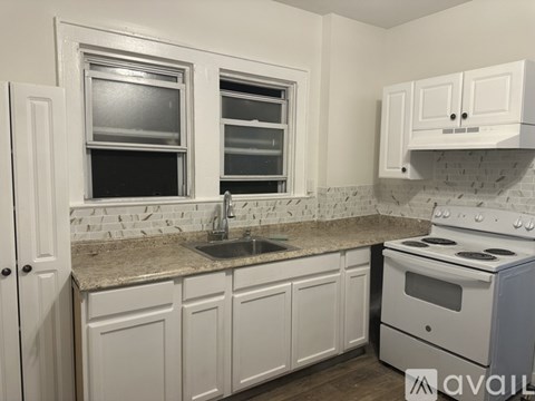 A kitchen with white cabinets and a white stove.
