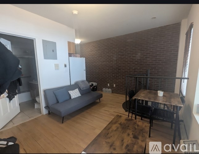 A living room with a grey couch and a wooden floor.