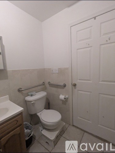 A white toilet in a small bathroom with a white door.