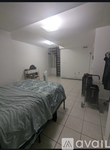 A bedroom with a bed, a chair, and a suitcase.