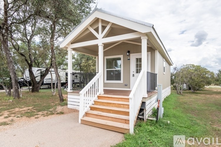 A small house with a porch and a staircase leading to the door.