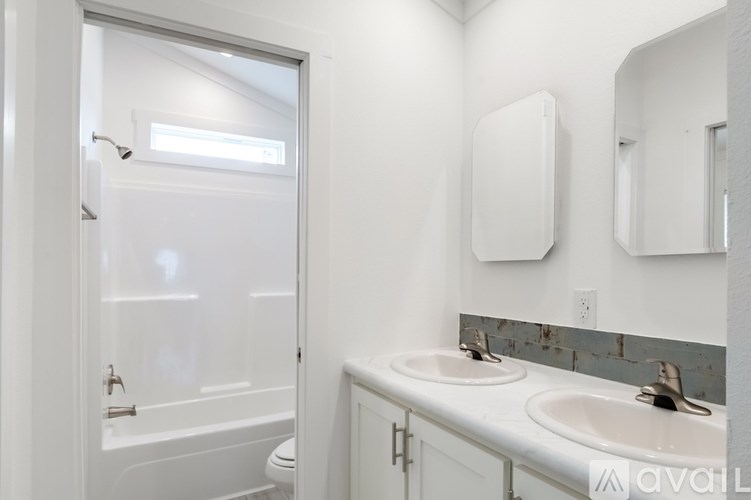 A white bathroom with a toilet, sink, and mirror.