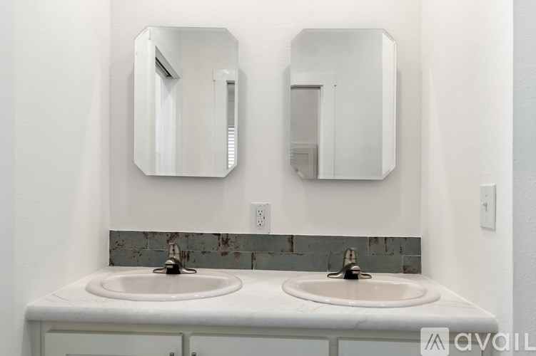 A bathroom with two sinks and two mirrors above them.