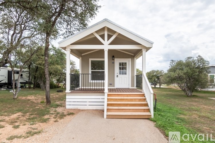 A small white house with a porch and a front door.