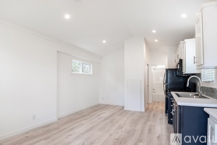 A kitchen with a sink, stove, and cabinets.