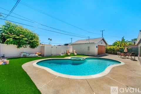 A backyard with a pool and a patio area.