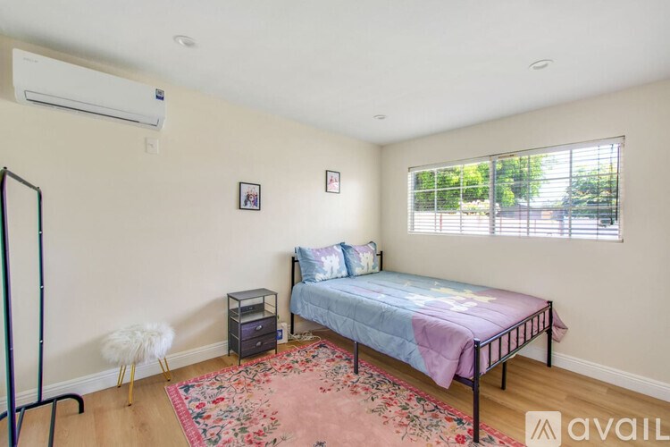 A bedroom with a bed, nightstand, and chair.