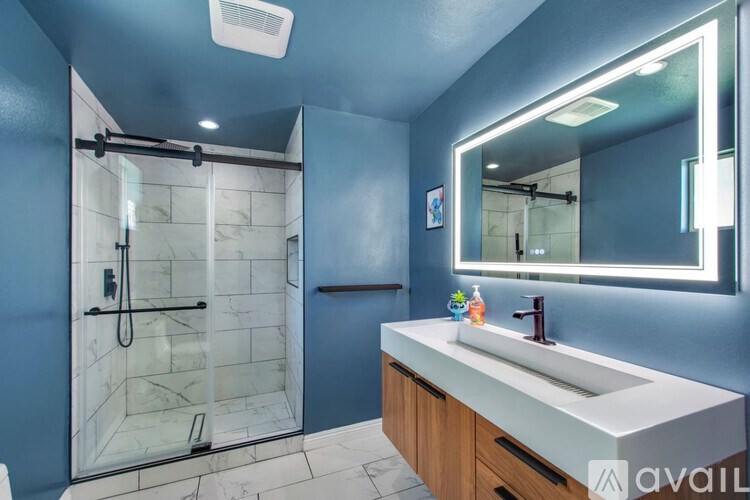 A bathroom with a blue wall and a white sink.